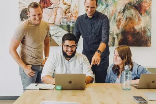 People reviewing a laptop together around a table